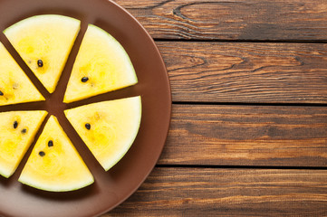 yellow watermelon slices on dark old wooden background top view