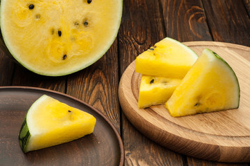 yellow watermelon slices on dark old wooden background