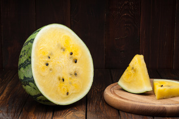 yellow watermelon slices on dark old wooden background