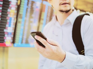 Business traveler using mobile phone during his journey at airport terminal