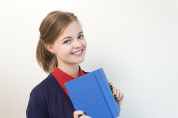 Obraz premium Beautiful caucasian young woman holding the blue book in front of her