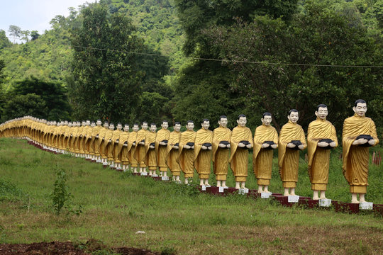 Simulated statue that's like a monk holding a almsbowl lined up beautiful at the temple in Myanmar.
