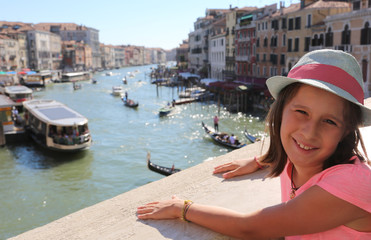 Fototapeta na wymiar little girl above the Rialto bridge in Venice in Italy and the b