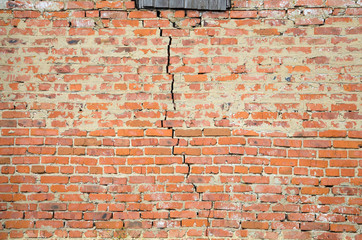 Red brick wall background with big crack