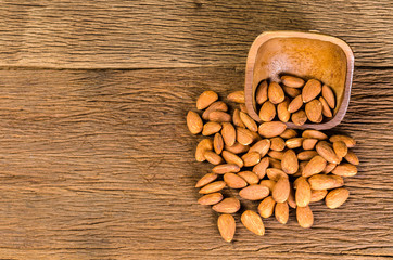 almond from wooden bowl on wooden board