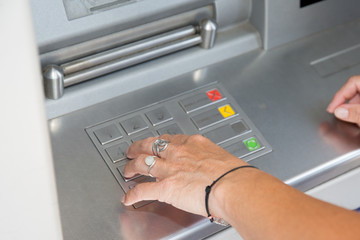 young woman arms at the cash machine