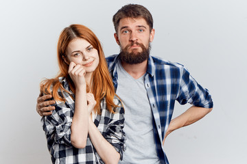 A man with a beard hugs a red-haired woman by her shoulder