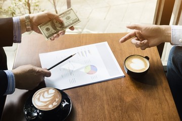 Business man is giving money to a partnership in coffee shop