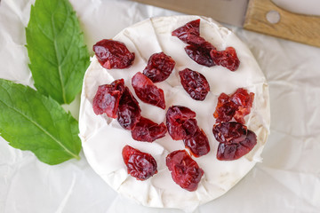 Dried cranberries on camembert cheese.  Top view.