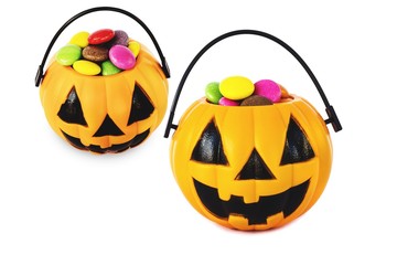 Halloween pumpkin face bucket with colorful candy inside isolated over white