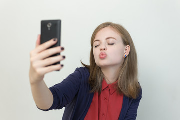 Young woman with a smart phone makes selfie