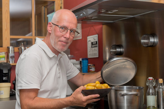 Mature Handsome Man Cooking In Home Kitchen