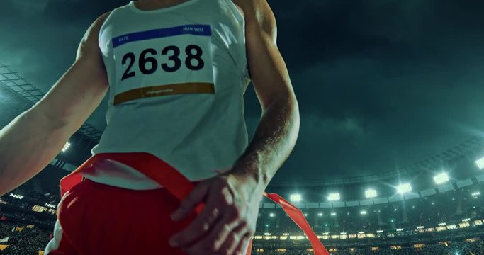 Male track and field runner crosses finishing line