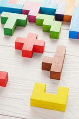 Different colorful shapes wooden blocks on wooden background.