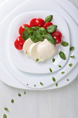 Mozzarella with tomato and green basil.