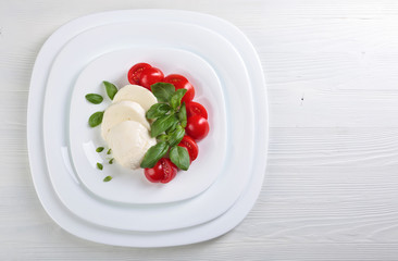 Mozzarella with tomato and green basil.