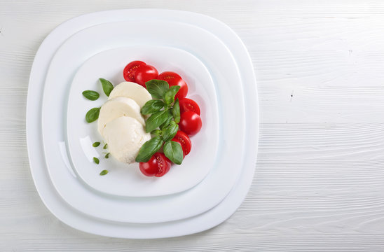 Mozzarella with tomato and green basil.