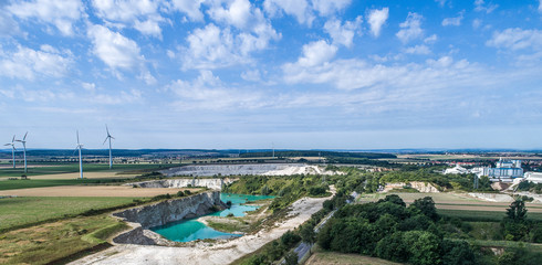 Limestone break from the distance, wind turbines in the background, dramatic skies