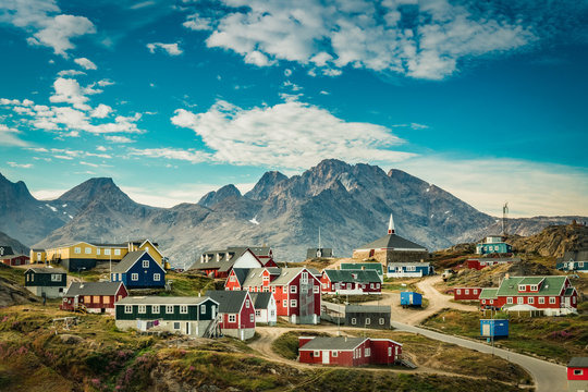 Small town on east coast of Greenland with colorful houses and mountain background