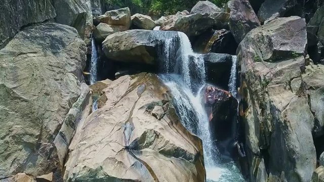 Drone Moves from Boulders across Waterfall to River