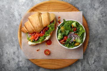 Croissant with salmon and salad in bowl