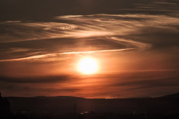 Bright sunset with gradient colors and a dark landscape.