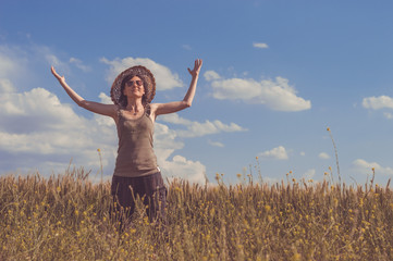 Young woman with hat enjoying the nature. Freedom concept.