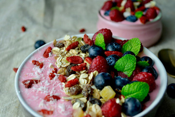 Smoothie Bowl with Raspberries, Blueberries, Goji berries, Granola and Mint..Heathy Breakfast