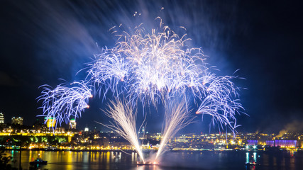 Blue fireworks over the Saint-Lawrence River with a part of Quebec city in the background. Quebec, Canada.