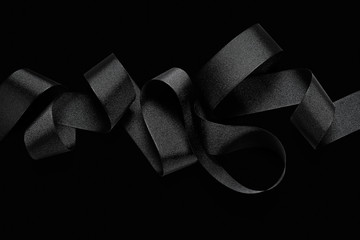 Close up of black ribbon isolated on black background