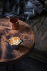 Coffee latte art on dark wooden table at coffee shop. Vintage color, filter effect