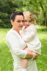 Beautiful child with mom in the summer. Green nature background