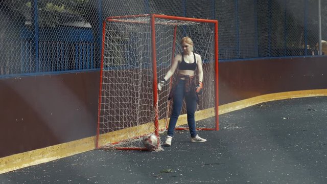 Female soccer player beats ball with his foot. Soccer goal. Woman football