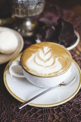 Coffee latte on the wooden retro table. Brekfast with chocolate and macaroons