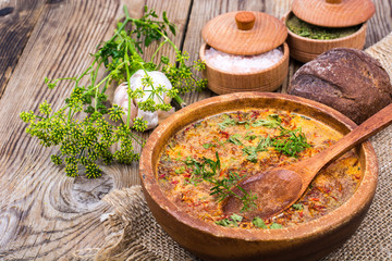 Village soup in wooden bowl on an old table