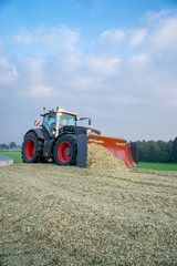 Traktor planiert Maishaufen, Hochformat