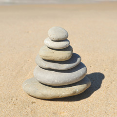 Fototapeta na wymiar Zen image, stones pyramid in sand