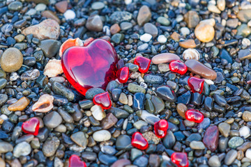 Fototapeta premium Pebble stones on the beach. Background of sea stones. stones with hearts. Red heart of the stones