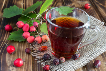 Tea with dogrose the wooden background