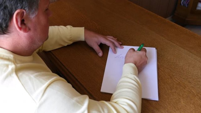 Man writes the word "holiday" on paper.