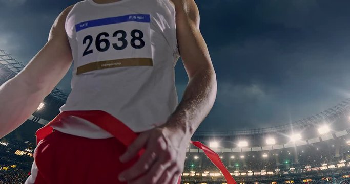 Male track and field runner crosses finishing line
