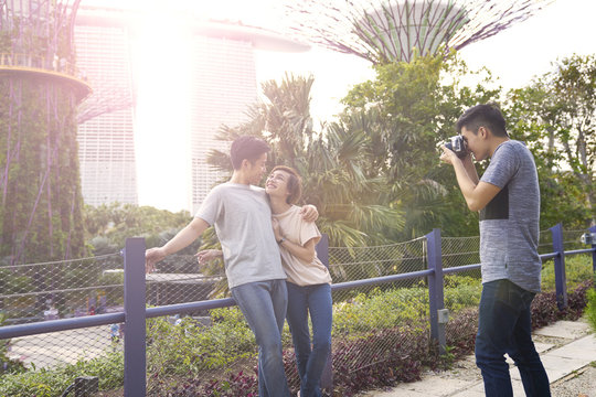 Young photographer takes a photo of a young couple at Gardens by the Bay