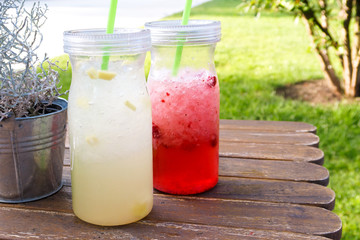 Lemon ginger and raspberry fruit smoothies on wooden table.