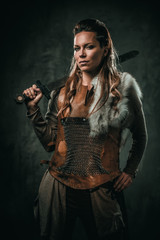 Obraz na płótnie Canvas Viking woman with cold weapon in a traditional warrior clothes