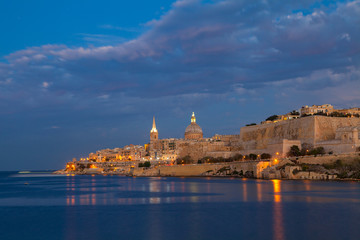 Summer amazing night view of Valetta profile over sea. Long exposure. Illuminated architecture.