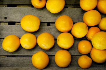 Oranges on rustic wooden board from above.