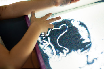 A boy and a girl are painting with sand. Sand animation