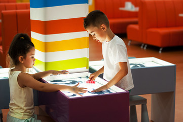 Naklejka premium A boy and a girl are painting with sand. Sand animation