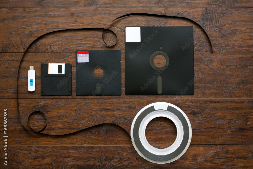 Wall mural the old 8-inch, 5.25-inch, 3.5-inch floppy disk, magnetic tape for an old ibm computer, a comparison