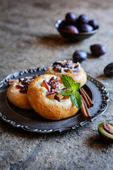 Fruit pies with sliced plum, cinnamon and crumble topping